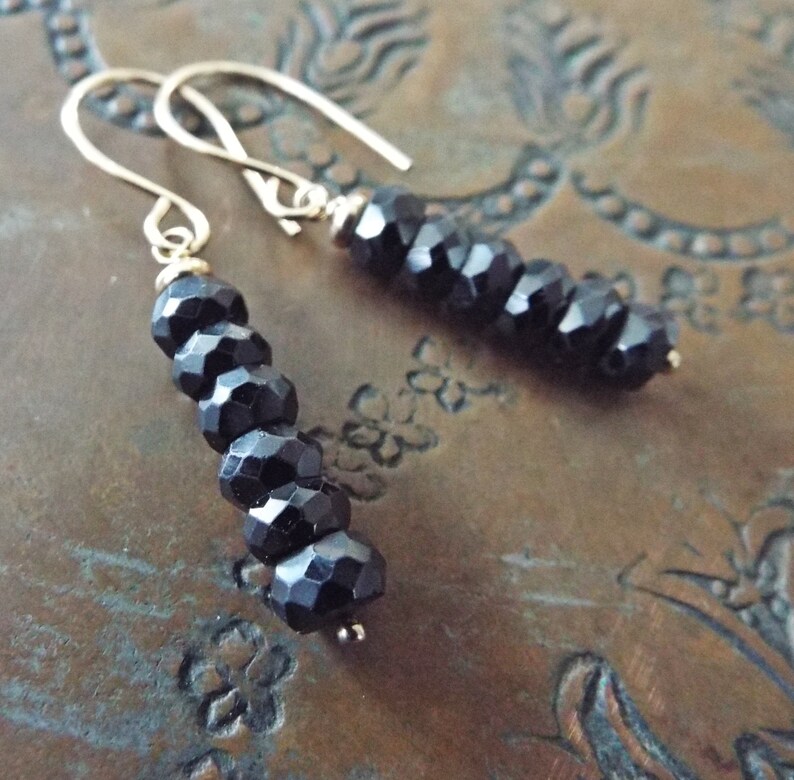 May include: A pair of dangle earrings with black faceted beads and gold hooks.