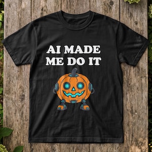 May include: A black short-sleeve t-shirt featuring the white text AI MADE ME DO IT above a graphic of a robotic orange pumpkin with glowing blue eyes and a mechanical mouth, standing on two small robotic legs with matching blue accents.