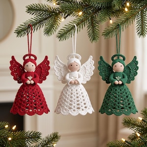 May include: Three crocheted angel ornaments in red, white, and green. Each angel features a round beige head, a halo, detailed wings, and a flared skirt with a scalloped hem. The figures are suspended by matching yarn loops for hanging.