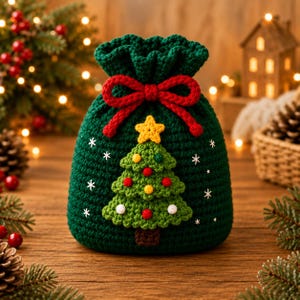 Pode incluir: Uma bolsa de crochê verde-escura com cordão e um laço de fio vermelho no topo. A frente apresenta uma árvore de Natal de crochê verde de três níveis com uma estrela amarela no topo, pequenos pompons coloridos e flocos de neve bordados em branco.
