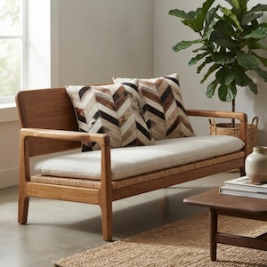 Puede incluir: Un sofá de dos plazas de madera con un cojín de asiento de color claro y dos cojines decorativos cuadrados con un patrón de chevrón en marrón, negro y blanco. La estructura es de madera natural con base tejida y el respaldo es de madera maciza.