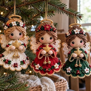 Puede incluir: Tres adornos de ángeles tejidos a ganchillo colgados de un árbol. Cada ángel tiene un halo dorado, una estrella en sus manos y una corona de flores. Los ángeles visten vestidos en blanco, rojo y verde, decorados con pequeñas flores y bayas.