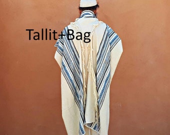 May include: A white tallit with blue and black stripes and fringes. The tallit is worn by a person with a white kippah. The text "Tallit+Bag" is visible in the image.