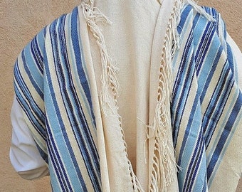 May include: A white prayer shawl with blue and white stripes and fringes. The shawl is folded in half and has a white lining.
