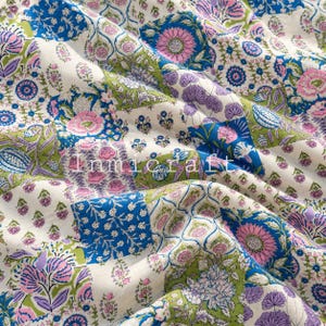 May include: A fabric featuring a patchwork design with floral and botanical patterns in shades of blue, pink, green, and white. The textile displays repeating motifs of flowers and leaves, with the text Inmicraft printed across the center.