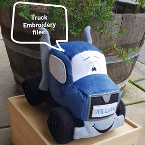 May include: Blue plush toy truck with a smiling face and the name "WILLIAM" embroidered on the front. The truck has black wheels and white accents.