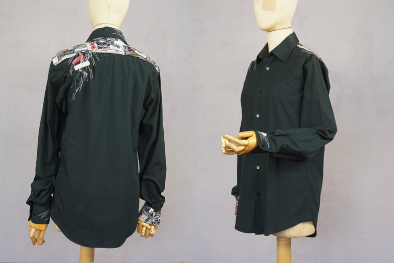 May include: A dark green long-sleeved button-up shirt with a unique design on the back and cuffs. The design features a variety of colorful fabrics and textures.