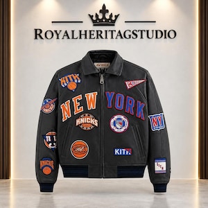 May include: A black leather varsity jacket featuring orange and blue New York Knicks and Kith patches. The front displays large orange and blue lettering reading NEW YORK, with various basketball-themed emblems, a zipper closure, and ribbed cuffs.