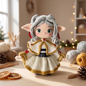 Peut inclure: Une poupée crochetée à la main avec des cheveux gris clair, des oreilles pointues et de grands yeux bleu sarcelle. La poupée porte une robe blanche avec une bordure dorée, une cape assortie et une ceinture noire. Des accents rouges ornent les oreilles.