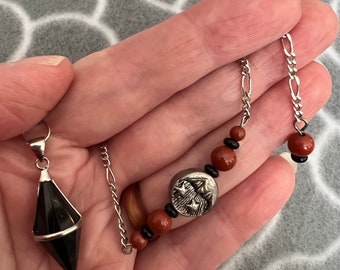 Pendulum of Obsidian, with carnelian and silver accents, includes sun and moon bead.