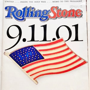 May include: A Rolling Stone magazine cover titled 9.11.01 featuring a blue, white, and red American flag pin. The text reads A SPECIAL ISSUE, THE REALITIES OF GROUND ZERO, HEROES OF NEW YORK, ELEGIES FOR AMERICA, MUSICIANS UNITED, INSIDE THE HOLY WAR.