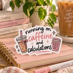 May include: A die-cut sticker featuring a graphic of an iced coffee cup with a pink bow and a pink calculator, with the text "running on caffeine and calculations" in black and pink script and print, accented by small four-pointed star icons.