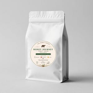 Könnte beinhalten: Ein weißer Standbodenbeutel mit Kaffee, der ein kreisförmiges Etikett mit dem Text "TEA HORSE COFFEE HONEY JOURNEY YUNNAN LANCANG SINGLE ORIGIN FRUIT-FERMENTED HONEY PROCESS" trägt. Das Etikett enthält Symbole für Bergamotte, Grapefruit und Zitrusfrüchte.