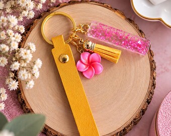 Handmade yellow and pink keychain with a soft pom-pom, pink flower, and glittery pendant; a unique accessory and gift idea.