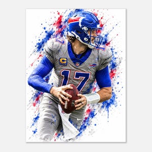Op de afbeelding: Een kunstprint in aquarel-stijl met een footballspeler in een grijs en blauw uniform met het nummer 17, een blauwe helm en een bruine football in de handen. Het ontwerp bevat levendige rode en blauwe verfspatten op een witte achtergrond.