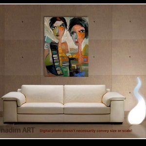 May include: Abstract painting of two women with colorful, stylized faces. The painting is framed and hanging on a wall above a white sofa.
