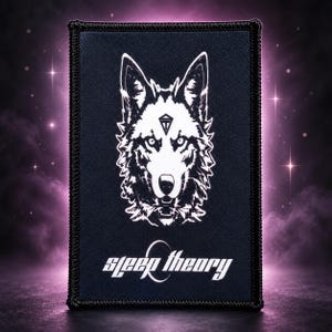 May include: A rectangular black patch with a white graphic of a wolf head featuring a small triangular symbol on its forehead. Below the wolf, the text "sleep theory" is printed in white letters with a circular accent over the letter e.
