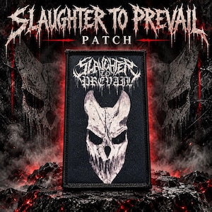 May include: A rectangular black fabric patch featuring the white text Slaughter to Prevail at the top and a stylised white horned skull graphic centred below. The patch has a stitched border and is displayed against a dark, smoky background.