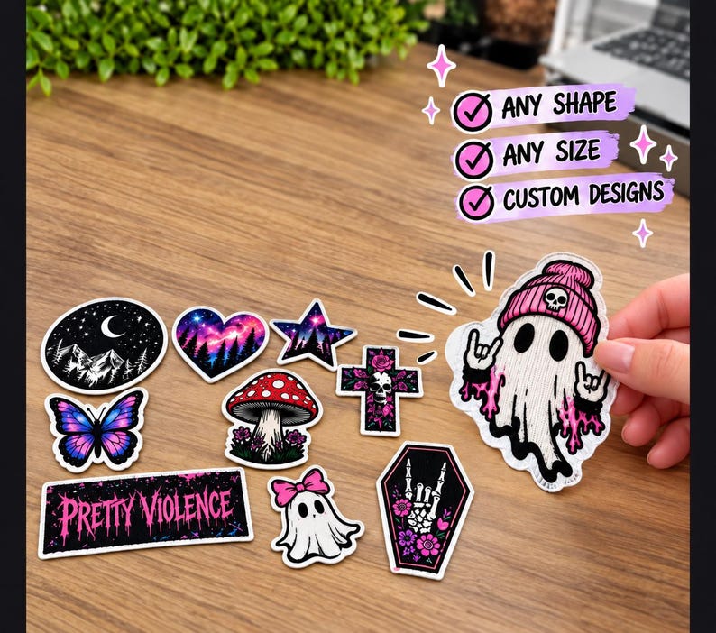 Pode incluir: Uma cole&ccedil;&atilde;o de autocolantes recortados com v&aacute;rios designs, incluindo uma lua crescente, um cora&ccedil;&atilde;o, uma estrela, uma borboleta, um cogumelo, uma cruz, um fantasma com gorro rosa, um caix&atilde;o e um autocolante retangular com o texto PRETTY VIOLENCE.