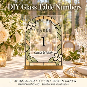 May include: A rectangular glass table number sign featuring a black arched frame with green and gold stained glass accents, displaying the text TABLE 1 and Olivia & Noah, set in a gold metal base, with DIY Glass Table Numbers text above.