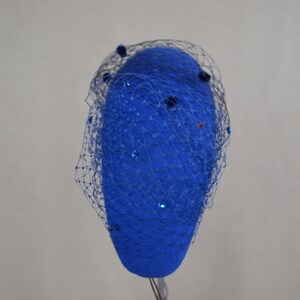 May include: A blue felt hat with a blue netting veil and blue sequins.