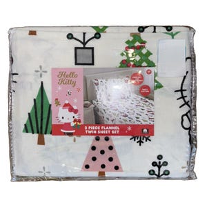 May include: A 3-piece flannel twin sheet set in white featuring a Hello Kitty holiday print with green and pink Christmas trees, snowflakes, and gifts. The packaging includes a product image showing the sheets on a bed and the text Hello Kitty.