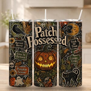May include: A cylindrical tumbler with a straw featuring a Halloween-themed design. The print includes a jack-o'-lantern, a black cat, a raven, a ghost, skulls, and text reading Patch Possessed, Harvest Horror, Glow In Darkness, and Pumpkin Season.