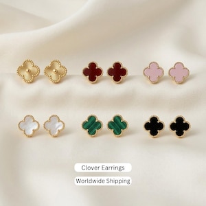 May include: Six pairs of clover-shaped stud earrings with beaded edges, featuring gold-tone, deep red, light pink, white, green striped, and black finishes. The text Clover Earrings and Worldwide Shipping is displayed at the bottom of the image.