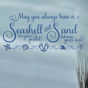 May include: Blue and white wall decal with the text "May you always have a Seashell and Sand in your pocket between your toes". The decal features a seashell, starfish, and flip-flops.