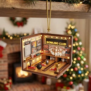 May include: A miniature bowling alley ornament featuring a wooden structure with two lanes, bowling pins, balls, red shoes, and a gold trophy. The interior is illuminated by string lights and displays a sign that reads BOWLING CLUB.