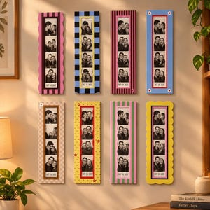May include: Eight vertical rectangular photo frames arranged in two rows on a wall. Each frame displays a black and white photo strip with the date OCT 26 2023. The frames feature various colorful patterns including stripes, checkers, and scalloped edges.