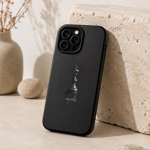 May include: A matte black smartphone case featuring a centered graphic of a single black chess king piece. Below the chess piece, the word "myself" is printed in a white, cursive script font. The case has a cutout for a triple-lens camera system.