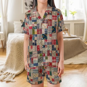 May include: A short-sleeve button-down shirt and matching shorts set featuring a multi-colored patchwork design. The fabric displays a variety of small square patterns in shades of red, blue, green, yellow, and white, with a notched collar.