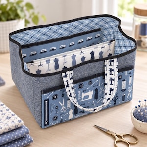Puede incluir: Un organizador de tela rectangular con exterior azul jaspeado y ribete negro. El interior tiene un forro azul claro con patrón de tijeras, mientras que el bolsillo frontal muestra un estampado azul de máquinas de coser, botones y cremalleras.