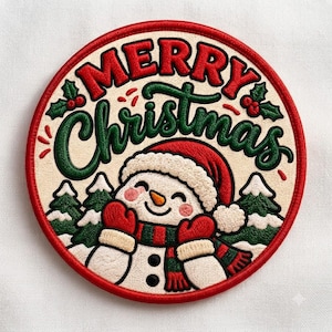 May include: A circular embroidered patch featuring a cream background with the red and green text Merry Christmas. The design includes a smiling snowman wearing a red hat and scarf, surrounded by green pine trees and red holly berries.