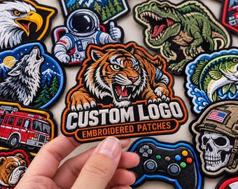 May include: A collection of embroidered patches featuring various designs including a tiger, a wolf, a dinosaur, an astronaut, a fire truck, a skull in a helmet, and a game controller. One patch in the center displays the text CUSTOM LOGO EMBROIDERED PATCHES.