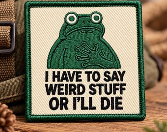 May include: A square embroidered patch with a cream-colored background and a dark green border. The patch features a green frog with its hand on its chest and the black embroidered text: I HAVE TO SAY WEIRD STUFF OR I'LL DIE.