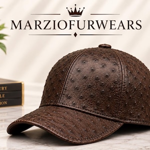 Puede incluir: Una gorra de béisbol de color marrón oscuro con un patrón texturizado similar al avestruz, con protuberancias en relieve. La gorra tiene una corona estructurada y una visera curva. El texto MARZIOFURWEARS aparece arriba con un icono de corona.