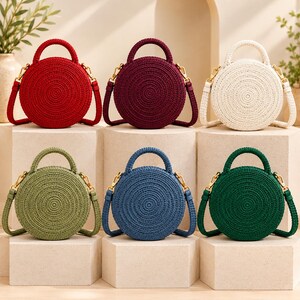 May include: Six round, crocheted handbags with top handles and gold-tone hardware. The bags are displayed in red, dark purple, cream, olive green, blue, and dark green, each featuring a circular, textured, spiral-stitched pattern.