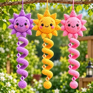 Könnte beinhalten: Drei gehäkelte Sonnen-Ornamente in Lila, Gelb und Pink, jedes mit einem lächelnden Gesicht mit schwarzen Augen und rosa Wangen. Unter jeder Sonne hängt ein gehäkelter Spiralschwanz, der mit vier facettierten Kristallperlen und einer Kugel verziert ist.