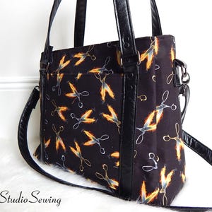 Bolso de estilista Flaming Scissors: bandolera de piel sintética, 35,5 cm de ancho x 28 cm de alto x 13,7 cm de profundidad, con múltiples bolsillos, cierre de cremallera y correa cruzada extraíble.