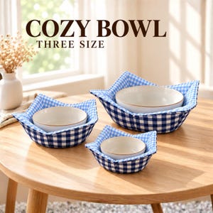 May include: Three fabric bowl holders in a blue and white gingham pattern, each containing a plain white ceramic bowl. The text COZY BOWL THREE SIZE is visible at the top. The holders have a star-like shape with pointed corners.