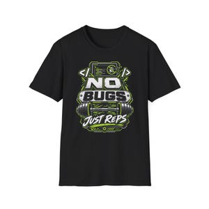 Può includere: Una t-shirt nera a maniche corte con una stampa grafica in bianco e verde lime. Il design include un bilanciere, parentesi di codice e il testo NO BUGS JUST REPS, con una piccola icona di un insetto all'interno di un cerchio sbarrato.