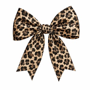 May include: A decorative bow featuring a tan and black leopard print pattern. The bow is constructed with two large upper loops and two downward-pointing tails with V-shaped notched ends, all tied together with a central knot of the same fabric.
