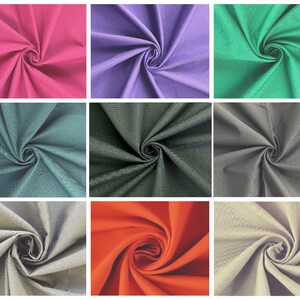 May include: A collection of fabric swatches in various colors, including red, purple, green, teal, gray, black, orange, and beige. The fabric is folded and arranged in a grid pattern.
