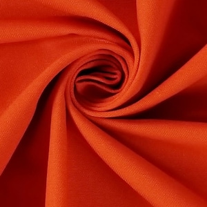 May include: Close-up of a bright orange fabric with a smooth texture. The fabric is folded and draped, creating a soft, flowing look.