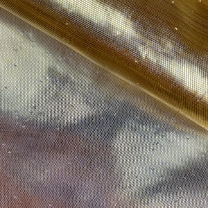 May include: Gold mesh fabric with a subtle shimmer. The fabric has a fine, even weave and a slightly textured surface.