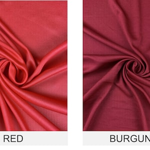 May include: Two fabric swatches, one red and one burgundy, are shown in a close-up view. The fabric is smooth and has a slight sheen.