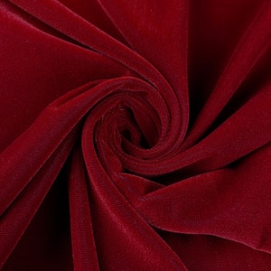 May include: Close-up of a deep red velvet fabric, showing the soft texture and rich color.
