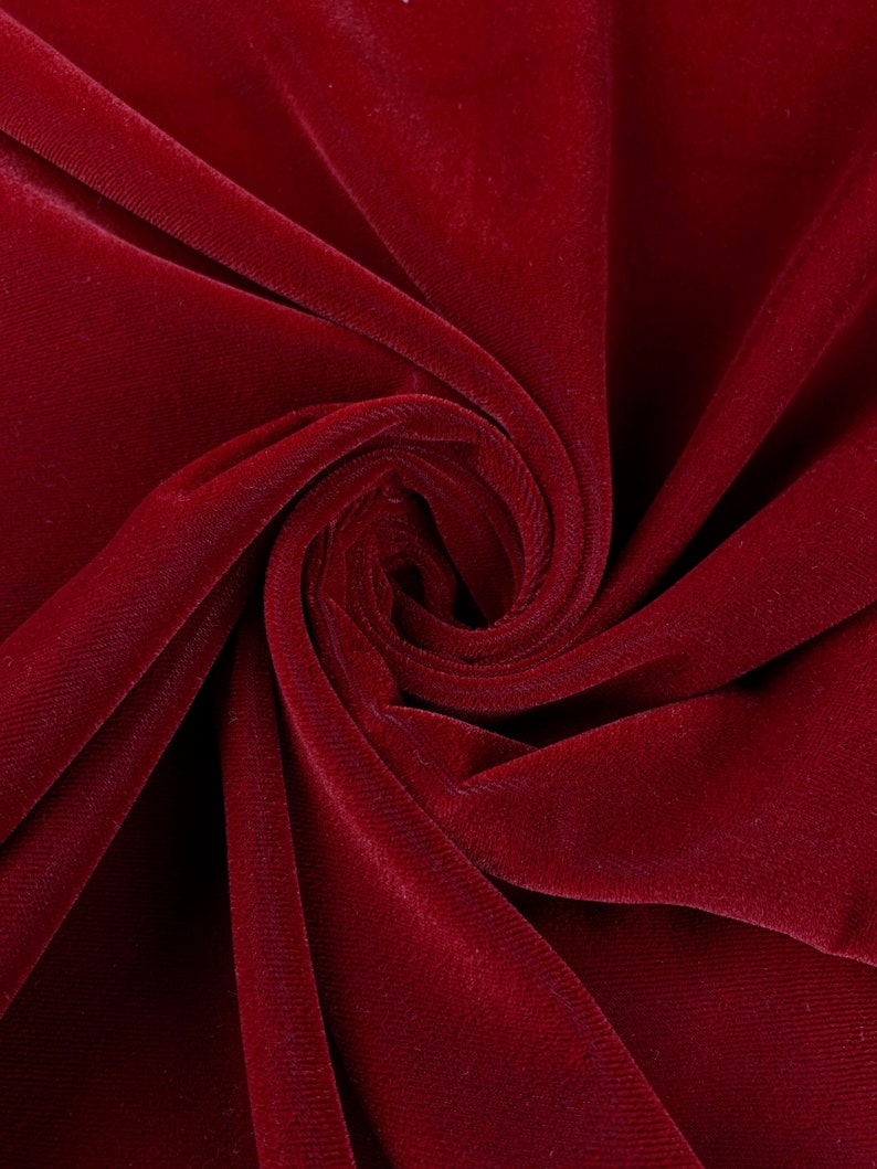May include: Close-up of a deep red velvet fabric, showing the soft texture and rich color.